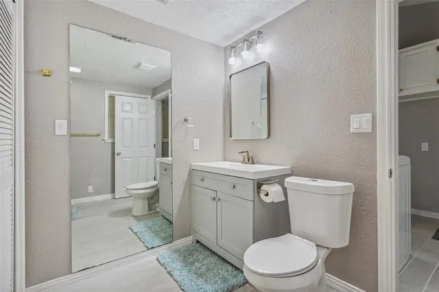 a bathroom with a toilet sink and mirror
