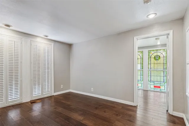 an empty room with wooden floor and a window