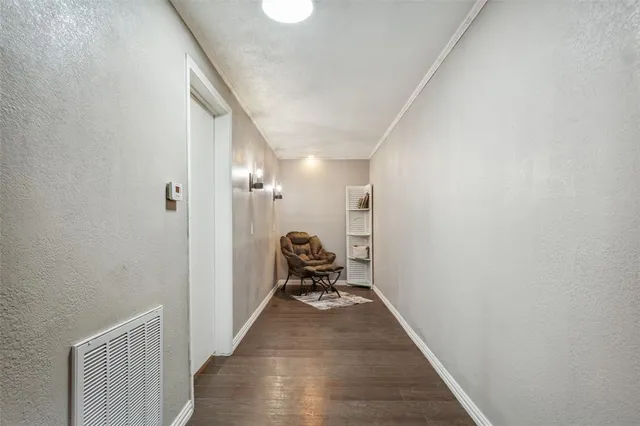 a view of a hallway with wooden floor and a white wall