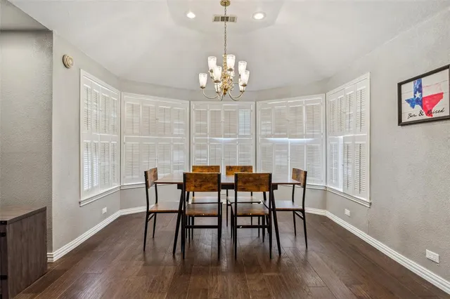 a view of a dining room with furniture a chandelier and wooden floor