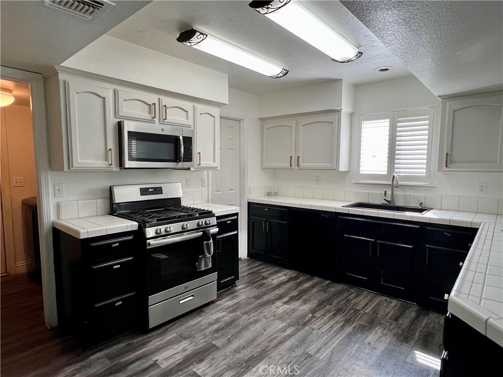 14016 Las Entradas Bakersfield, CA 93314 - Photo 11 of 25 a kitchen with a sink stove and microwave