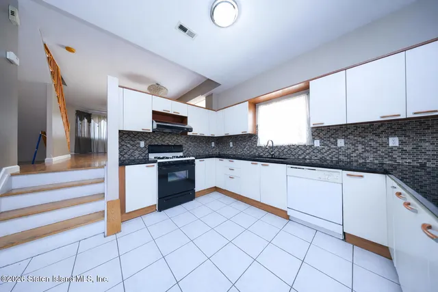 a kitchen with granite countertop a sink and a stove