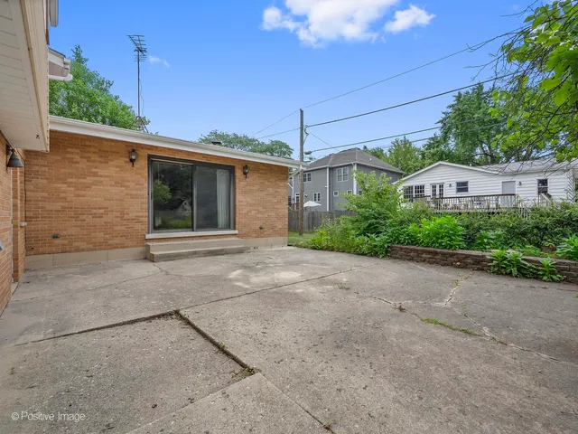 a view of a house with a yard and potted plants
