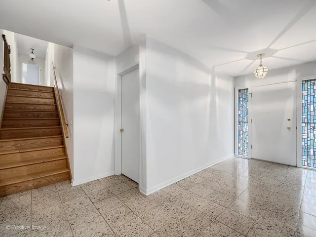 a view of an empty room with wooden floor and entryway