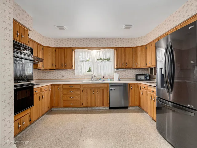a kitchen with granite countertop a refrigerator stove top oven a sink and dishwasher