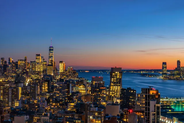 a living room with furniture large windows and wooden floor