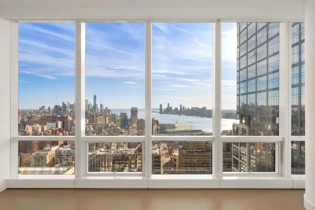 a large white kitchen with lots of counter space a sink a window and chairs