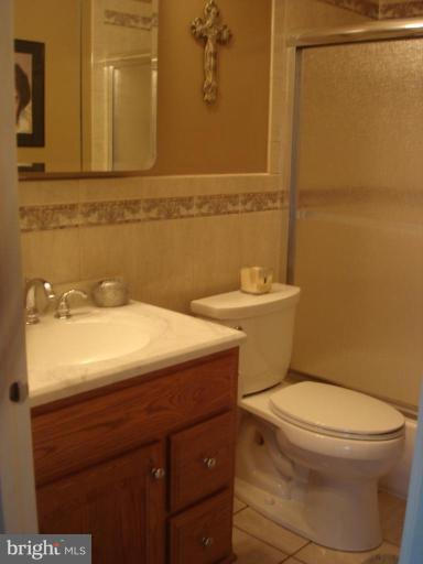 9311 Pella Place Clinton, MD 20735 - Photo 14 of 24 a bathroom with a sink a toilet and mirror