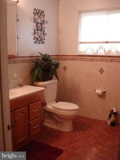 9311 Pella Place Clinton, MD 20735 - Photo 15 of 24 a bathroom with a toilet a sink and a window