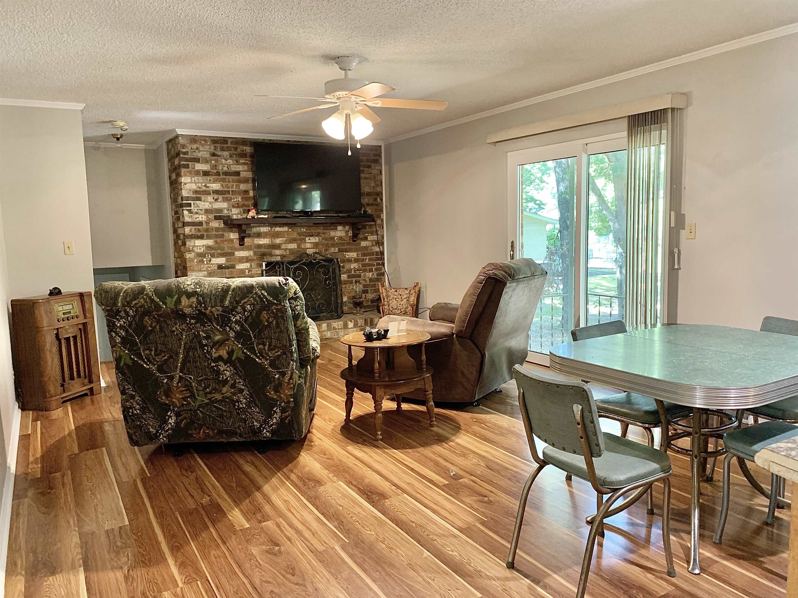 1038 Lake Street Bolivar, TN 38008 - Photo 4 of 31 Dining room with ornamental molding, a textured ceiling, a brick fireplace, and wood-type flooring