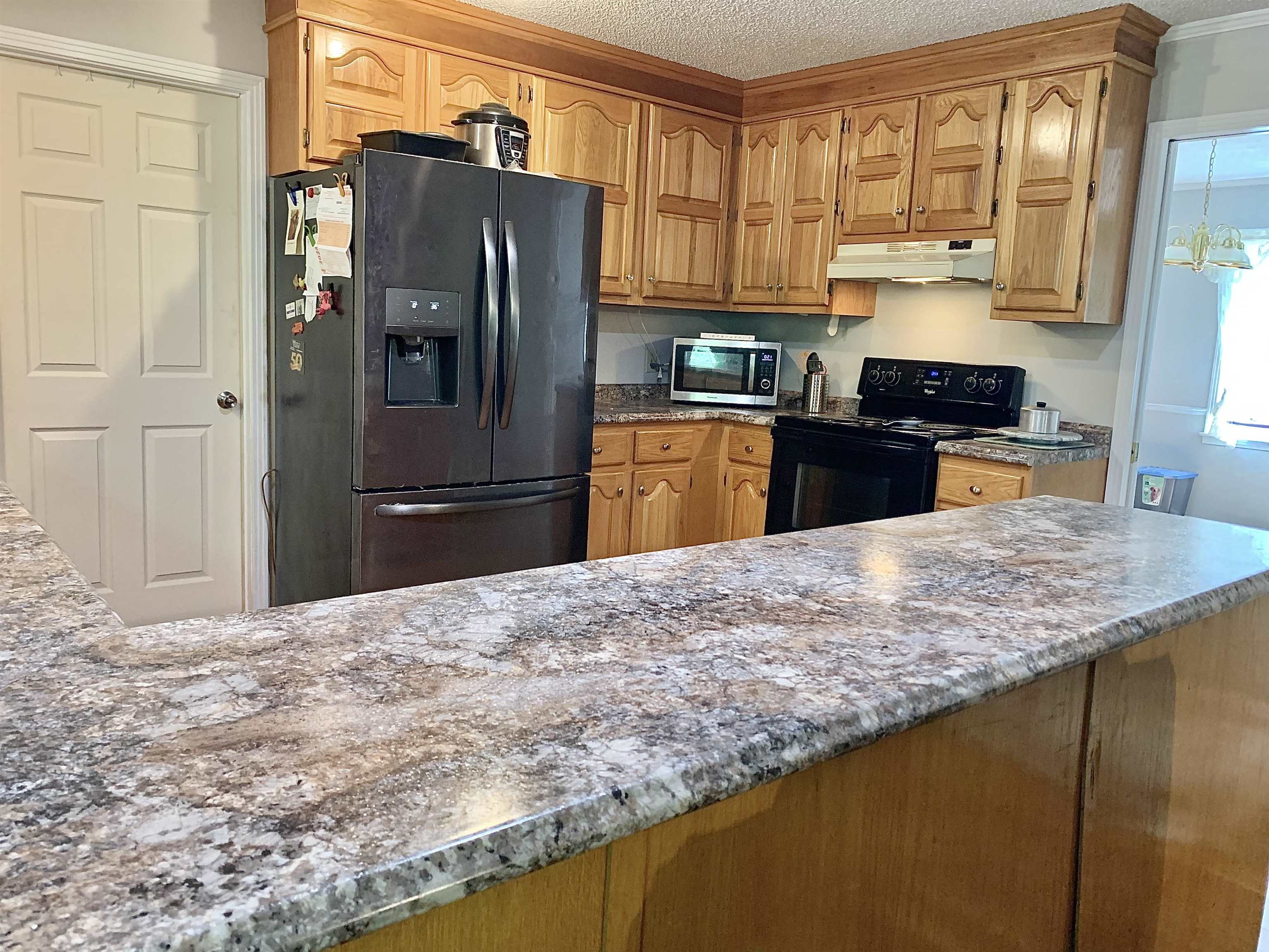 1038 Lake Street Bolivar, TN 38008 - Photo 5 of 31 Kitchen featuring appliances with stainless steel finishes, crown molding, a textured ceiling, and an inviting chandelier