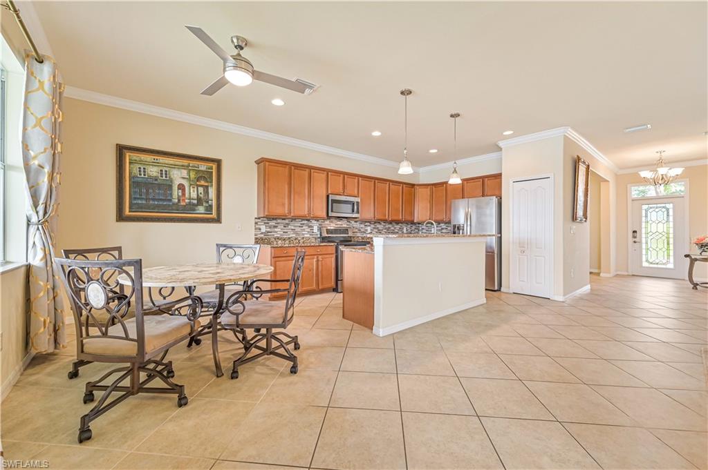 11686 Eros Road Lehigh Acres, FL 33971 - Photo 15 of 44 a kitchen with stainless steel appliances kitchen island granite countertop a refrigerator and a stove top oven