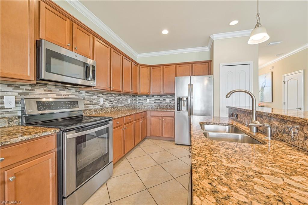 11686 Eros Road Lehigh Acres, FL 33971 - Photo 17 of 44 a kitchen with stainless steel appliances granite countertop a stove a sink and a microwave