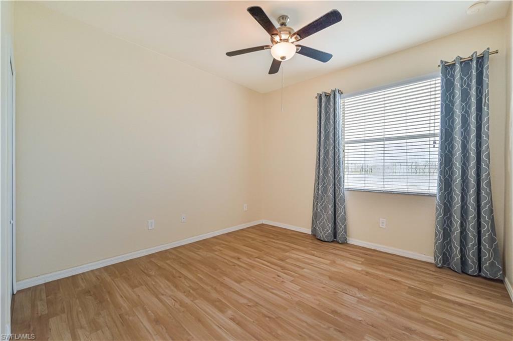 11686 Eros Road Lehigh Acres, FL 33971 - Photo 20 of 44 an empty room with wooden floor and windows