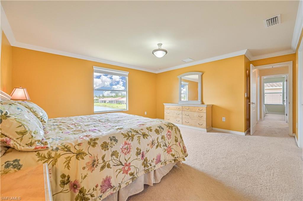 11686 Eros Road Lehigh Acres, FL 33971 - Photo 27 of 44 a bedroom with a large bed and a chandelier