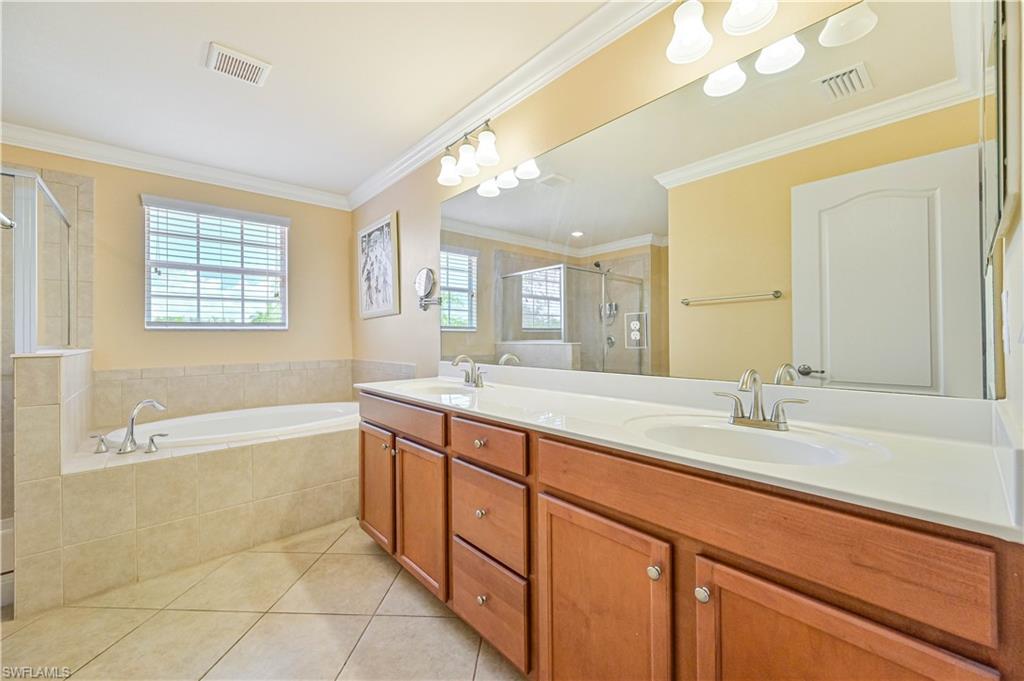 11686 Eros Road Lehigh Acres, FL 33971 - Photo 29 of 44 a spacious bathroom with a granite countertop sink mirror and a bathtub