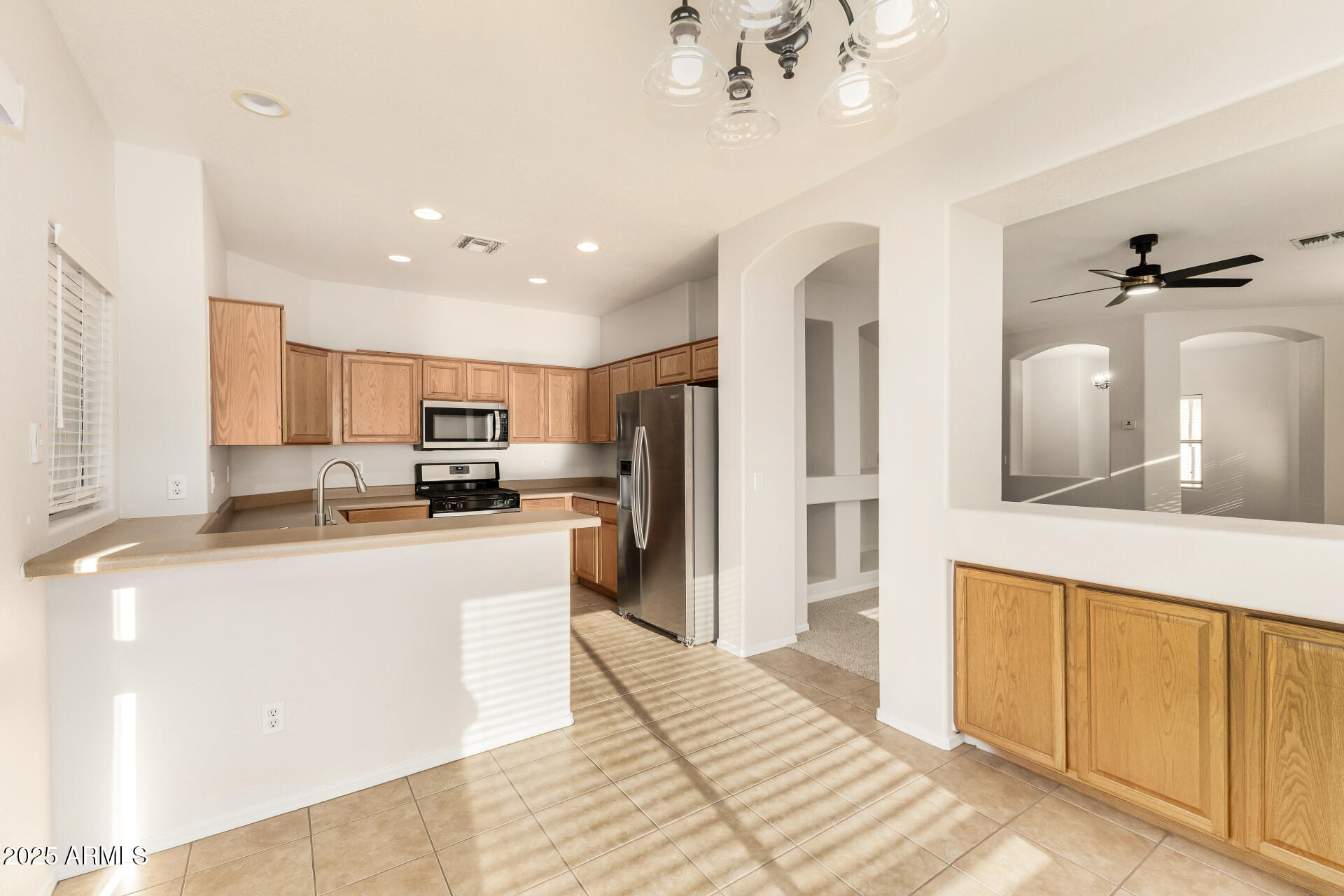3622 South Joshua Tree Lane Gilbert, AZ 85297 - Photo 15 of 37 a kitchen with stainless steel appliances kitchen island granite countertop a refrigerator oven a sink dishwasher and white cabinets with wooden floor