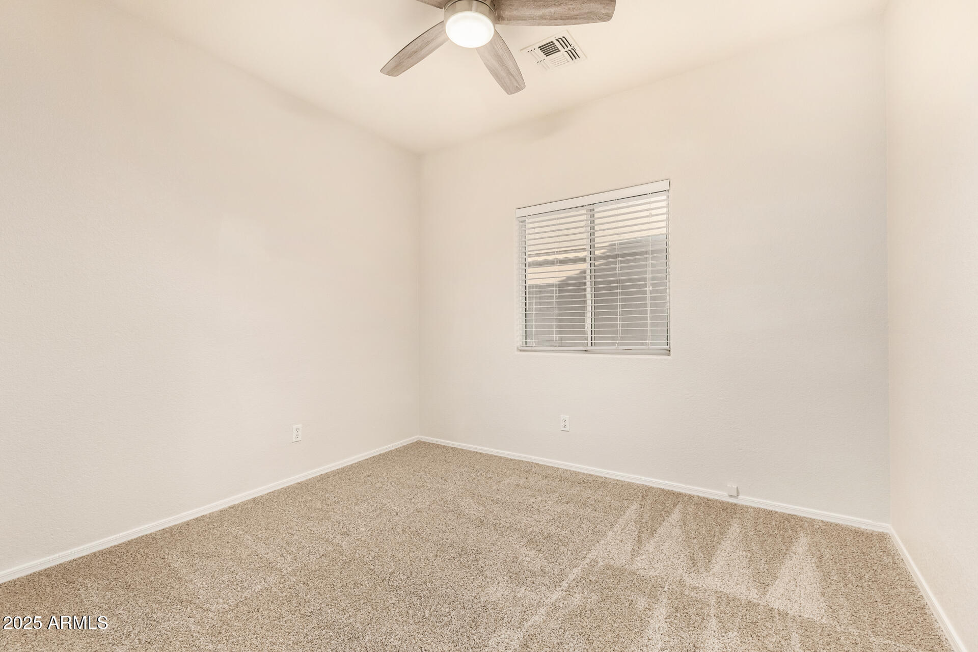 3622 South Joshua Tree Lane Gilbert, AZ 85297 - Photo 27 of 37 an empty room with a chandelier fan and windows