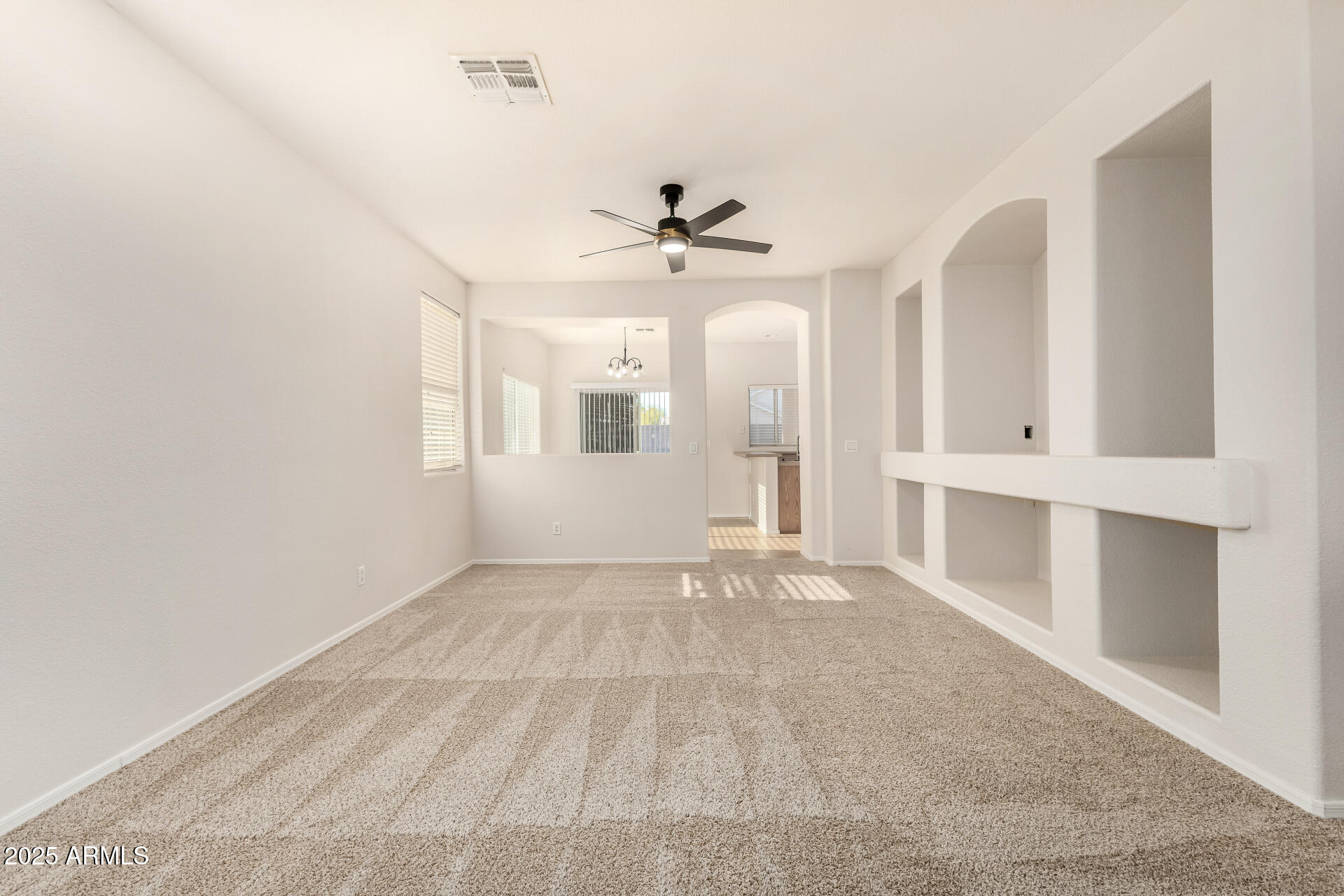 3622 South Joshua Tree Lane Gilbert, AZ 85297 - Photo 7 of 37 an empty room with chandelier fan and windows