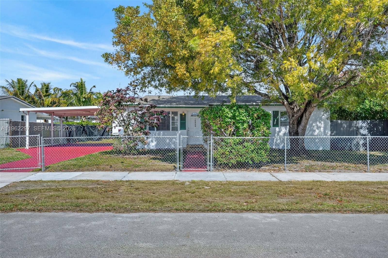 10325 Southwest 149th Terrace Miami, FL 33176 - Photo 1 of 34 a view of yellow house with a big yard and potted plants