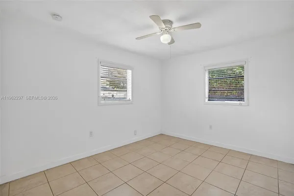 a bedroom with a bed a window and potted plant