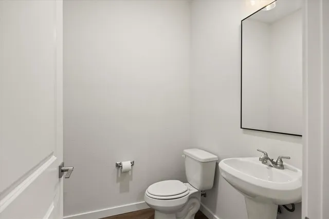 a bathroom with a sink toilet and a mirror