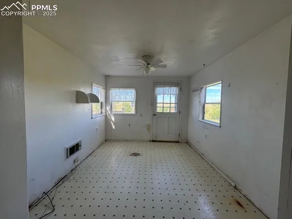 an empty room with a window and a ceiling fan