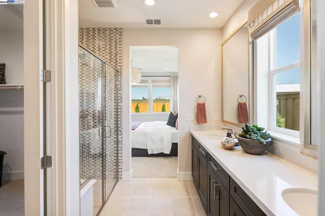 a spacious bathroom with a double vanity sink and mirror