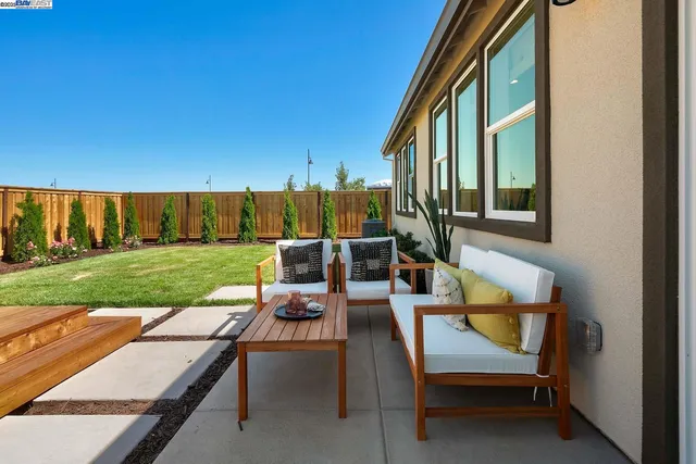 a view of a chair and tables in the back yard of the house