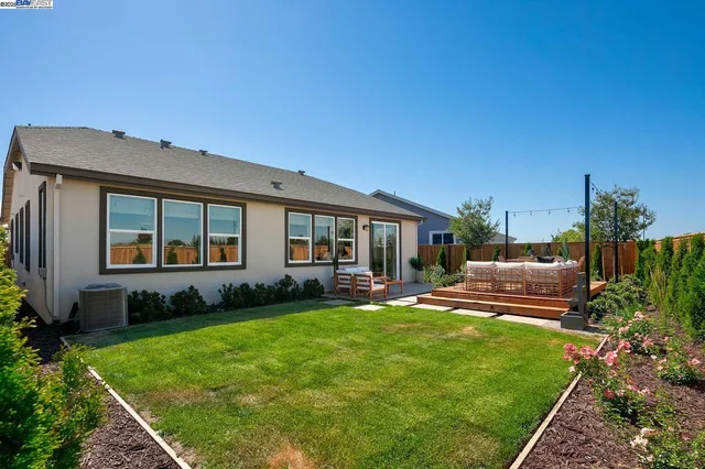 a view of a house with backyard sitting area and garden