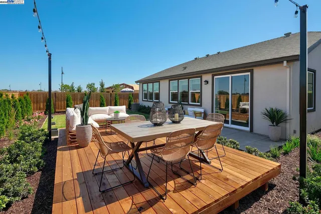 a view of a patio with table and chairs with wooden floor and plants