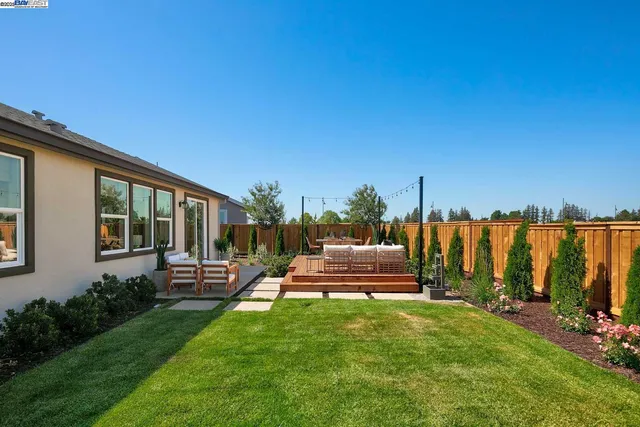 a view of a house with backyard and sitting area