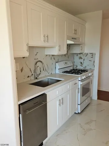 a kitchen with white cabinets and white appliances