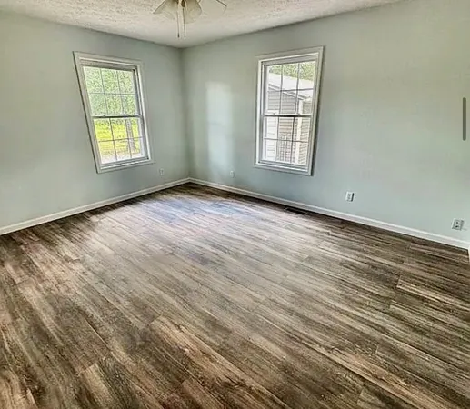 an empty room with windows and closet