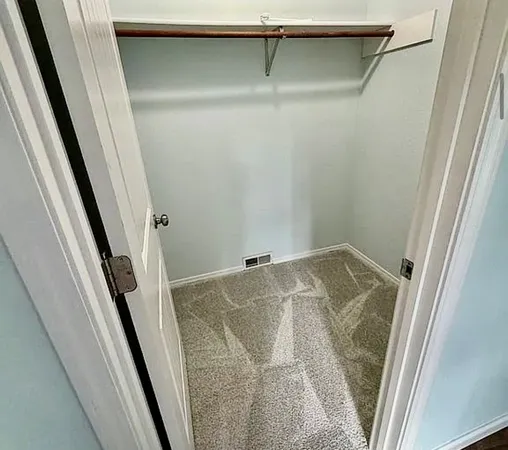 a view of walk in closet with wooden floor and stairs