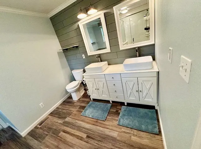 a kitchen with granite countertop a refrigerator a stove and wooden floors