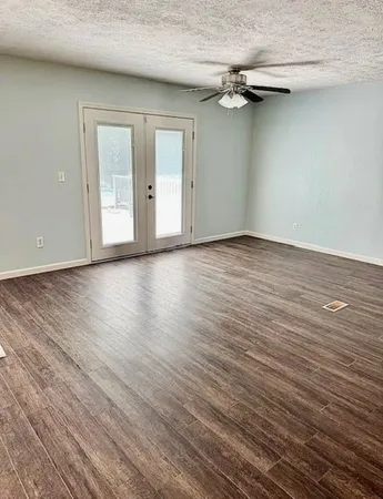 a view of an empty room with wooden floor