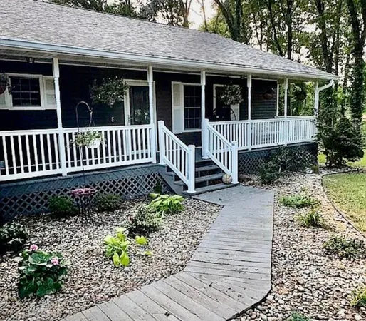 a view of a house with a small yard and wooden floor and fence