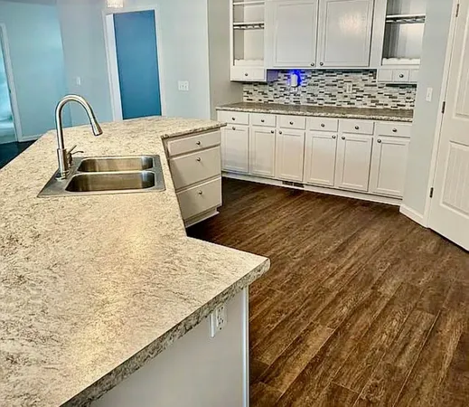 a kitchen with granite countertop a stove a sink and a microwave