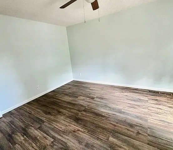 a view of a room with wooden floor and white walls