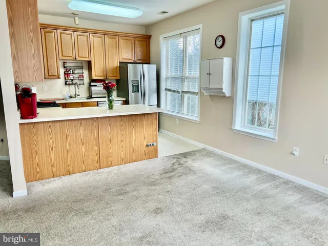 a view of kitchen with stainless steel appliances granite countertop a refrigerator and a sink