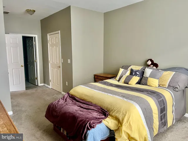 a bed sitting in a bedroom next to a bathroom