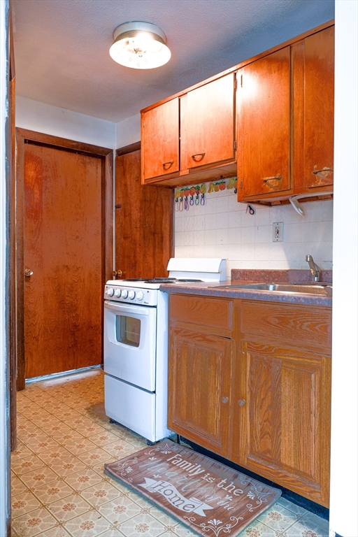 851 Broadway, Unit 21 Everett, MA 02149 - Photo 5 of 10 a kitchen with a stove and a cabinet
