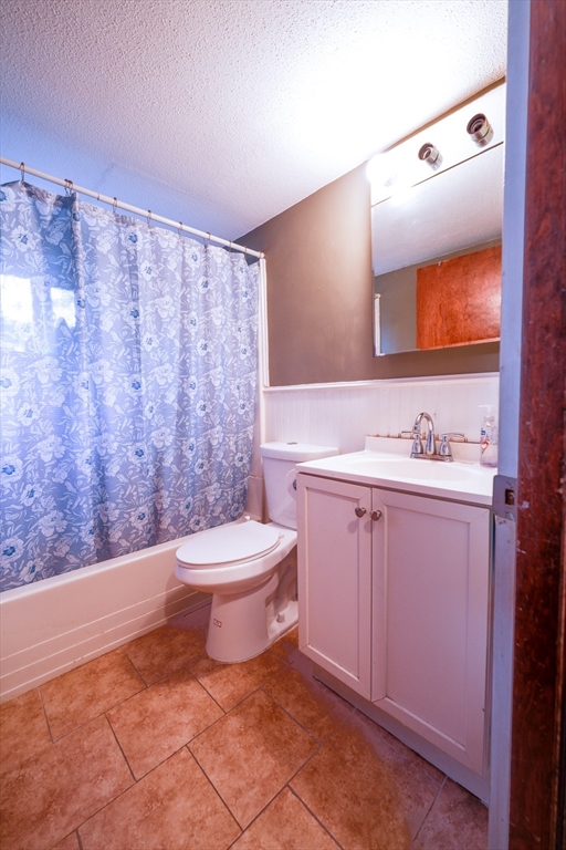 851 Broadway, Unit 21 Everett, MA 02149 - Photo 6 of 10 a bathroom with a granite countertop sink mirror vanity and toilet