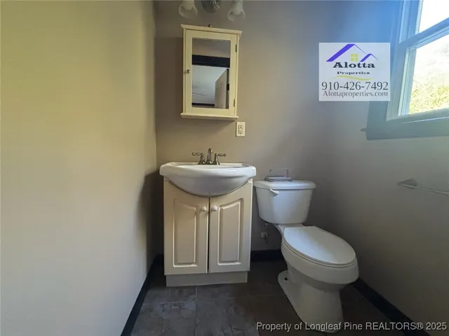 a bathroom with a toilet a sink and a window