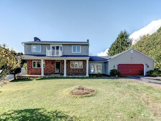 a view of a house with a yard and sitting area