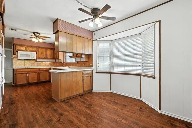 a kitchen with stainless steel appliances cabinets a large window and a sink