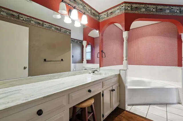 a bathroom with a granite countertop sink mirror and a bathtub