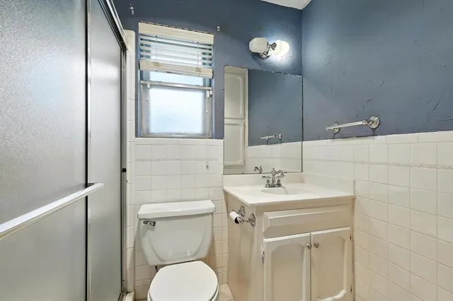 a bathroom with a toilet a sink a mirror and vanity