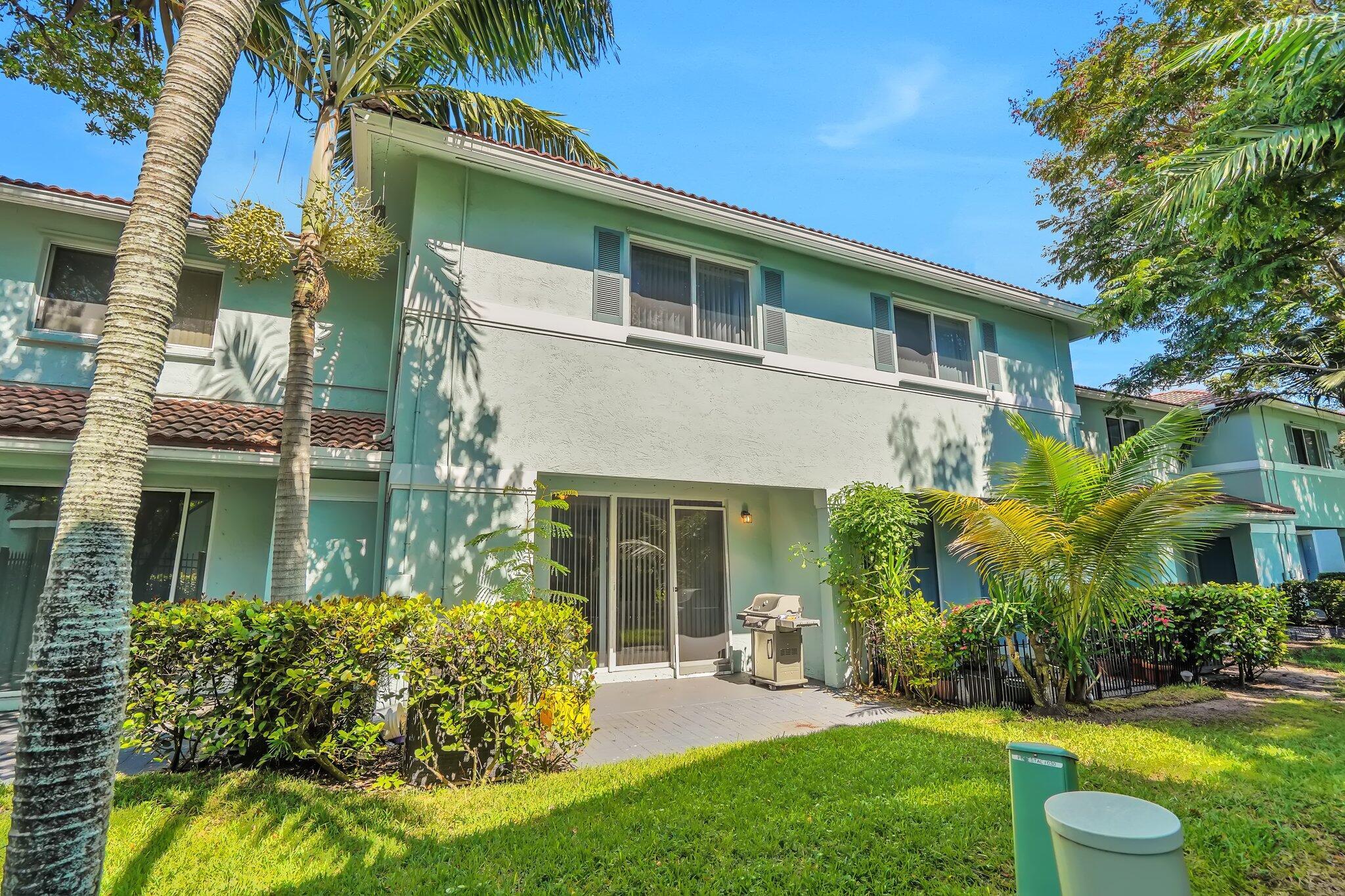 1969 Alamanda Way, Unit 1969 Riviera Beach, FL 33404 - Photo 13 of 26 a front view of a house with a yard